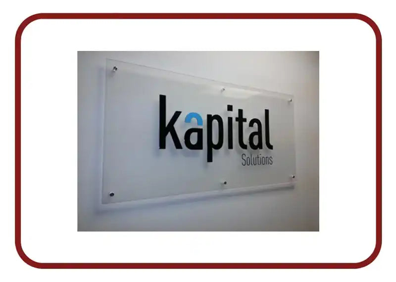 Clear acrylic wall sign displaying ’Kapital Solutions’ with a blue accent in the logo.